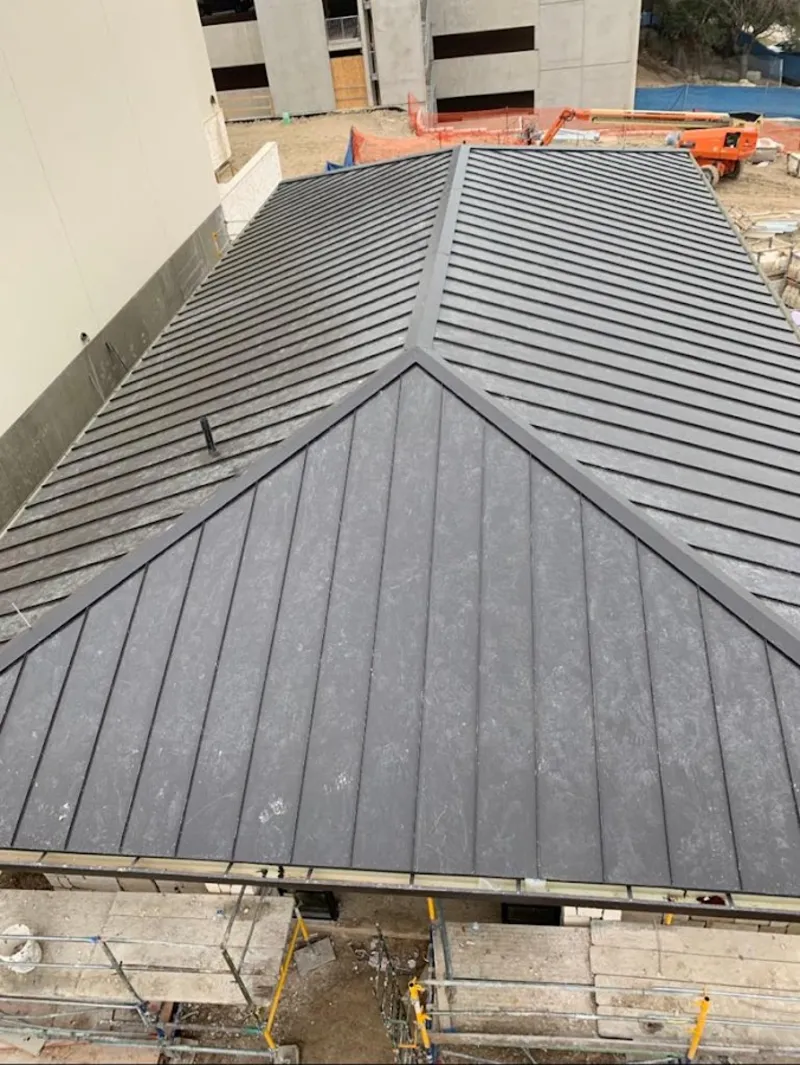 Commercial metal roof construction with crane equipment in Snellville